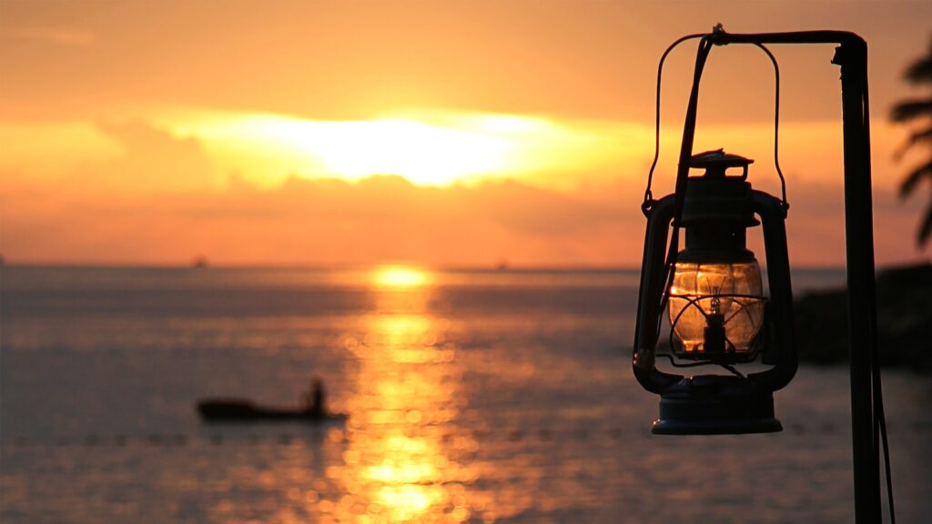 Night sky friendly gas lantern hanging next to the sea
